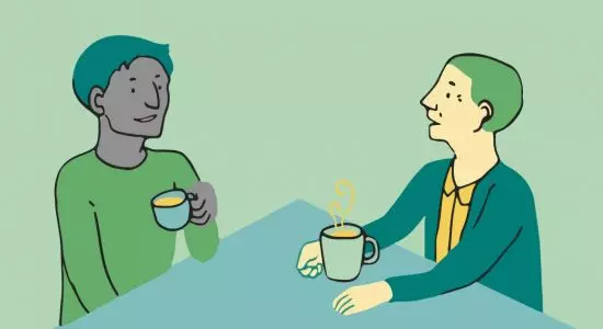 Image of two people talking over coffee